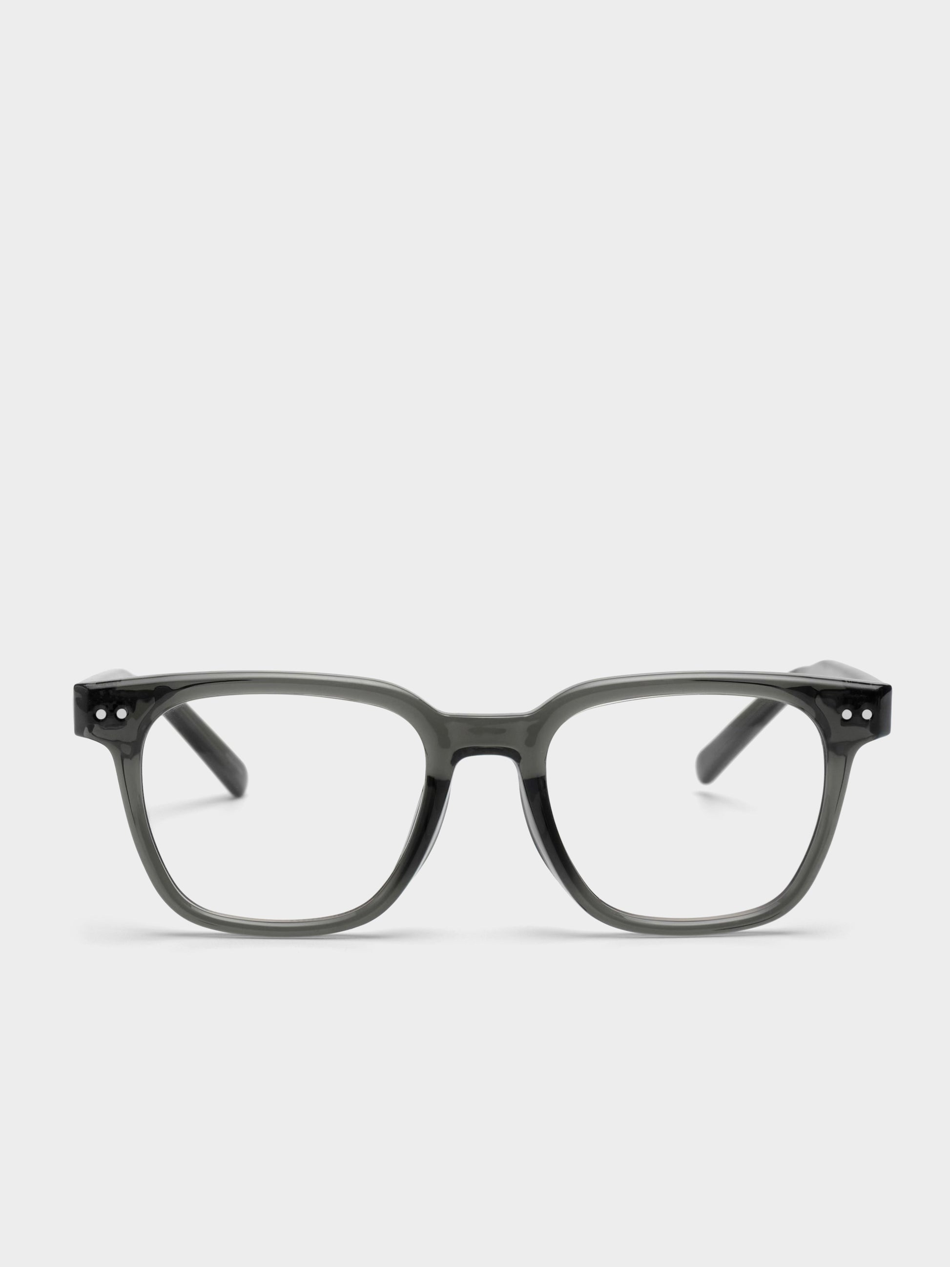 Dark green eyeglasses on a light gray background